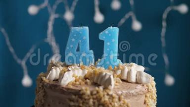 生日蛋糕，蓝色背景上有41支蜡烛。 蜡烛吹灭了。 慢动作和特写